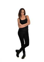 full length portrait of brunette girl wearing black singlet, jeans jeans and boots. standing pose, isolated on white studio background.