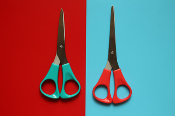 Blue scissors on the red, red scissors on the blue background