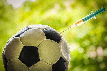 Soccer ball gets an injection / Soccer ball gets an injection with a syringe, doping in sports.