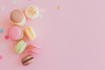 modern food photography concept. stylish colorful macaroons on trendy pink paper, flat lay. space...