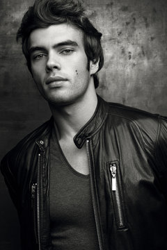 Stylish young man in black leather jacket. Contrast black and white portrait