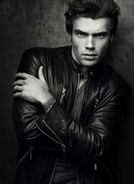 Fashion portrait of handsome young man in a black leather jacket