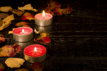 Lighted candle on the background of a large number of wilted leaves