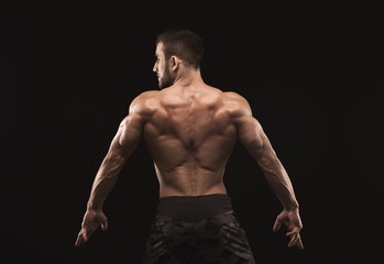 Fototapeta na wymiar Unrecognizable man shows strong back muscles closeup