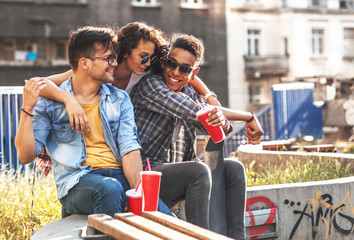 Group of friends hangout  at the street.They embrace each other and drinking cold juice.Fast food.