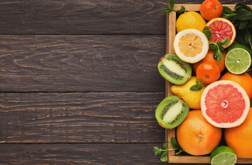 Variety of ripe citruses on wooden background