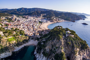 Aerial view of picturesque rocky landscape with fortified walls and residential buildings of Tossa de Mar, Spain