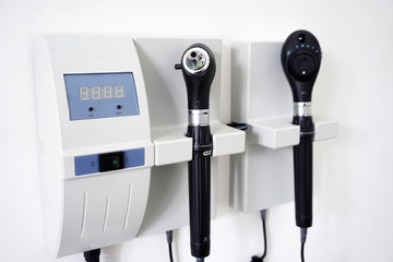 Medical Equipment with otoscope ear scope and ophthalmoscope eye scope hanging on a doctor's office...