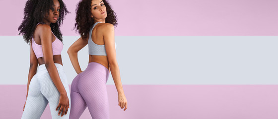 Two fitness women in sportswear isolated over gray background. Sport and fashion concept wit chopy space. © Mike Orlov