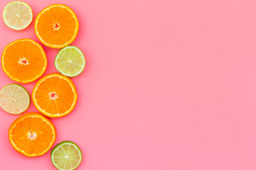 Citrus frame. Oranges and lime round slices composition on pink background top view copy space