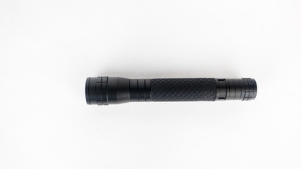 A black flashlight on an isolated white background