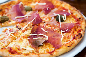 Close up view of delicious pizza with prosciutto