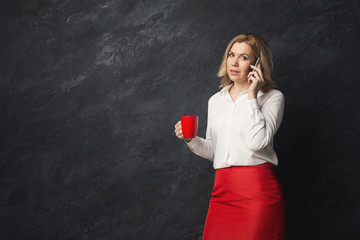 Thoughtful woman talking on phone in studio