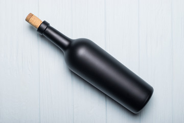 Wine bottle on white wooden background. Mock-up