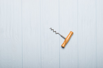 Corkscrew opener for wine cork on wooden background. Bottle-screw to open wine alcohol bottle at...