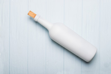 Wine bottle on white wooden background. Mock-up