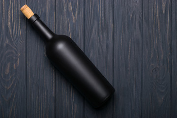 Wine bottle on dark wooden background. Mock-up