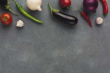 Border of fresh vegetables on grey background