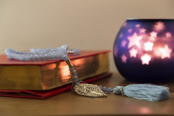  Koran and rosary on the white background with  candle for Islamic concept. Holy book Quran for Muslims for Ramadan and three months.