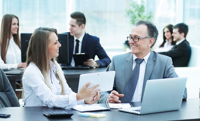 employees using digital tablet to work with financial data