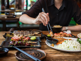Beautiful asian woman eating sashimi, Woman enjoy eat japan food in Tradition japan restaurant.