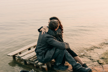 couple hugging and kissing on a pier