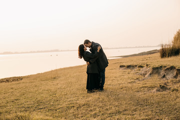 couple hugging and kissing on a pier