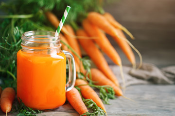 Fresh Carrot and carrot juice on Wooden Table in Garden. Vegetables Vitamins Keratin. Natural Organic Carrot lies on Wooden background.