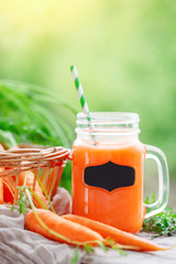 Fresh carrots and carrot juice in the garden. Harvest. Selective focus. Background with copy space.