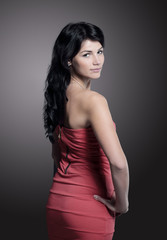 Fototapeta premium beautiful young woman in a red dress. isolated on black
