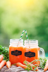 Fresh carrots and carrot juice in the garden. Harvest. Selective focus. Background with copy space.