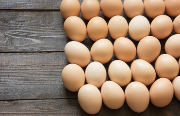 a lot of chicken eggs lie on a wooden table. view from above. place for text
