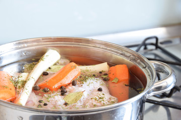 vegetables prepared with spices for cooking chicken broth in a metal pot