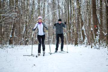 Fototapeta na wymiar Image of sports woman and man skiing in winter forest