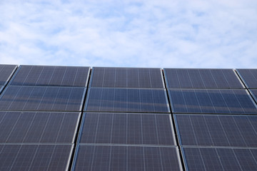 solar panels on a roof wiith blue sky with some clouds