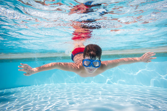 Boy in mask dive in swimming pool
