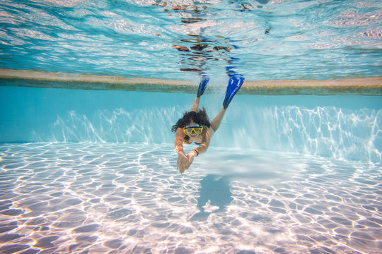 Girl in mask dive in swimming pool