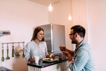 Couple eating breakfast at kitchen counter.