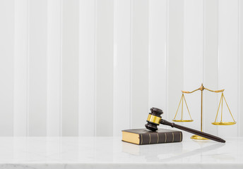 Wooden gavel and law book put on white marble table top counter with copy space.