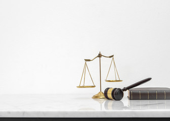 Wooden gavel and law book put on white marble table top counter with copy space.