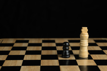 close-up of the black pawn and the white king, Chess board on dark background