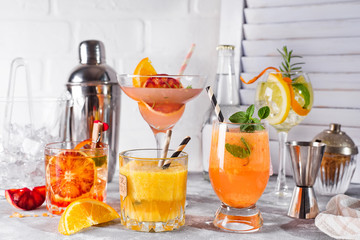 Set of classic cocktails of gin tonic with orange, with lime and mint leaves in glasses on white...