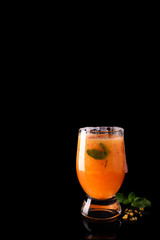 Paloma cocktail with fresh grapefruit, orange and mint on a black glass background