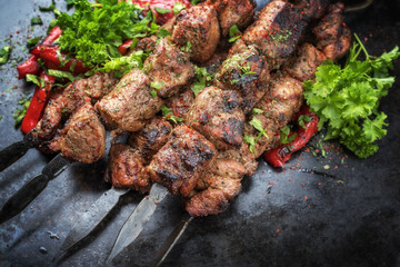 Traditionelles russisches Schaschlik auf Grillspießen mit Paprika als closeup auf einem alten Board