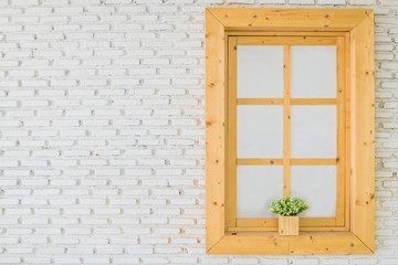 Fototapeta premium Brown wooden glass window with flowers inside on the white facade