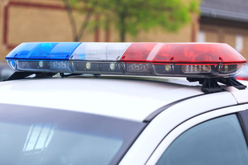 Blue and red flashing sirens of police car during the roadblock in the city. Police patrol car with...