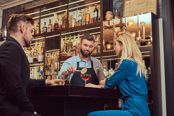 Stylish brutal barman serves an attractive couple who spend an evening on a date.