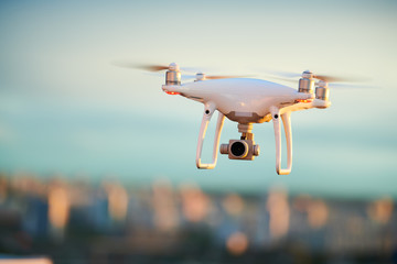 drone flying over evening city with digital camera