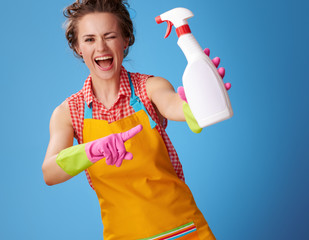 happy woman winking and pointing at bottle of detergent on blue