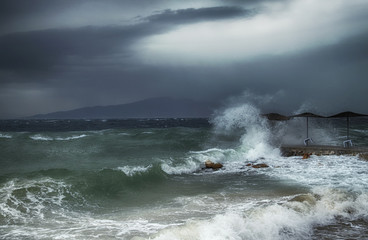strong storm, waves and wind at sea, waves washed away beach umbrellas
